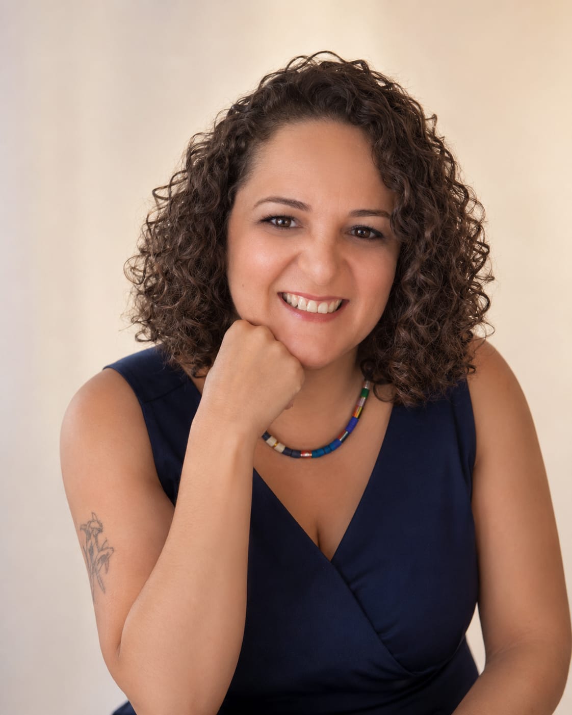 Retrato de Vivi Gäspar sorrindo, com o rosto apoiado sobre a mão